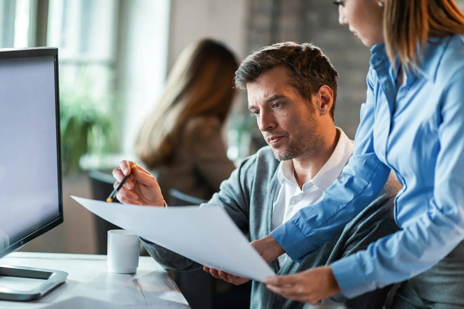 An accountant and a manager reviewing tax documents together at a desk