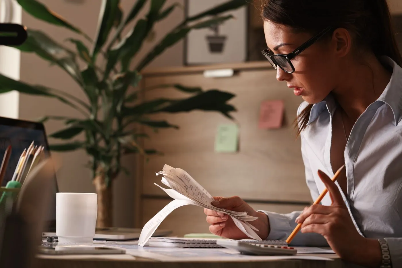 An accountant going through bills and receipts at her desk